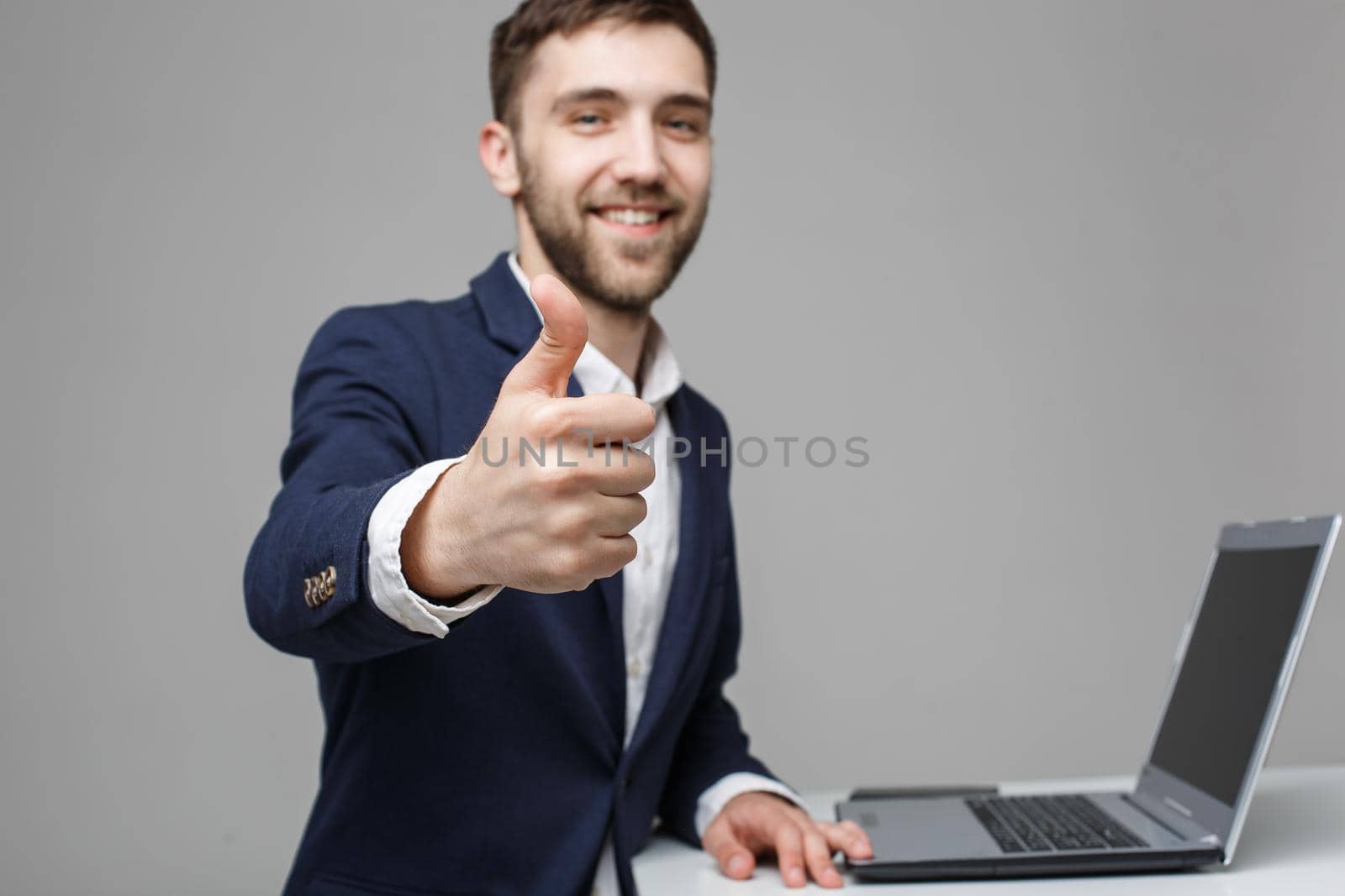 Business Concept - Portrait Handsome Business man showing thump up and smiling confident face in front of his laptop. White Background.Copy Space.