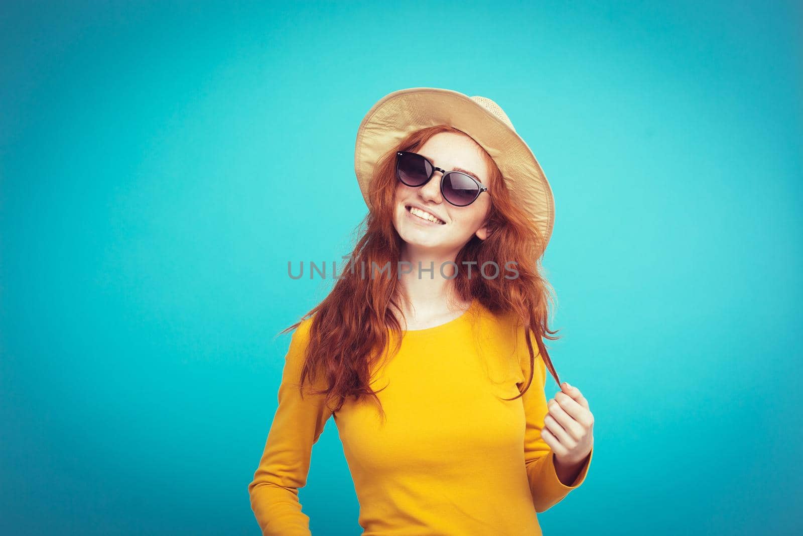 Travel concept - Close up Portrait young beautiful attractive redhair girl wtih trendy hat and sunglass smiling. Blue Pastel Background. Copy space by Benzoix