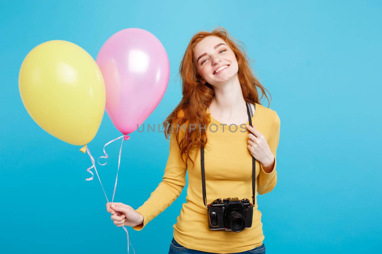 Lifestyle and Party concept - Close up Portrait young beautiful attractive ginger red hair girl with colorful balloon and vintage camera. Blue Pastel Background. Copy space. by Benzoix