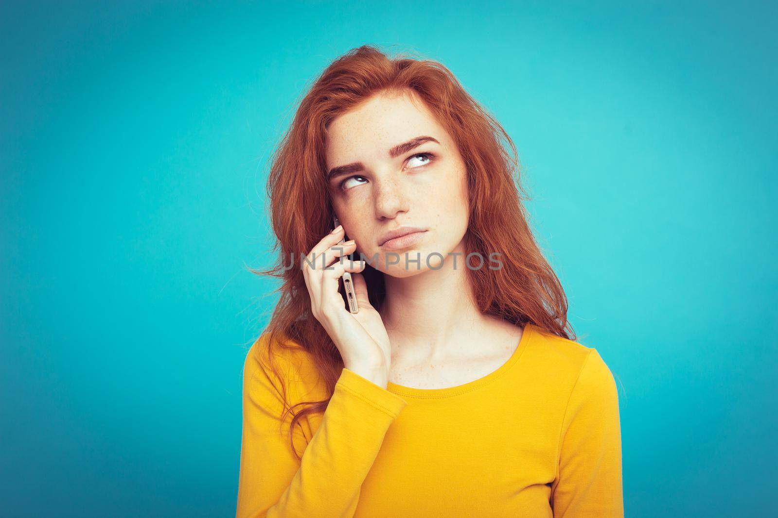 Lifestyle concept - Portrait of ginger red hair girl with shocking and stressful expression while talking with friend by mobile phone. Isolated on Blue Pastel Background. Copy space by Benzoix