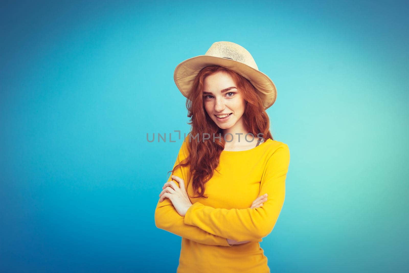 Travel concept - Close up Portrait young beautiful attractive redhair girl wtih trendy hat and sunglass smiling. Blue Pastel Background. Copy space by Benzoix