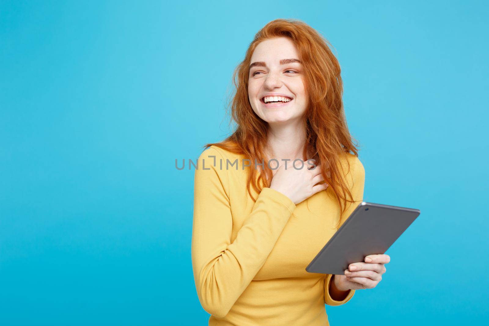 Close up Portrait young beautiful attractive tender ginger redhair girl happy smiling on digital table with wining something. Blue Pastel Background. Copy space. by Benzoix