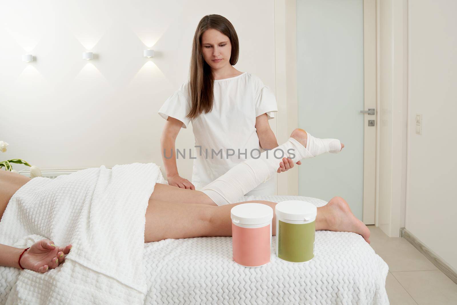 Anti-cellulite wraps procedure for legs in a spa center. Clear skin and perfect body concept