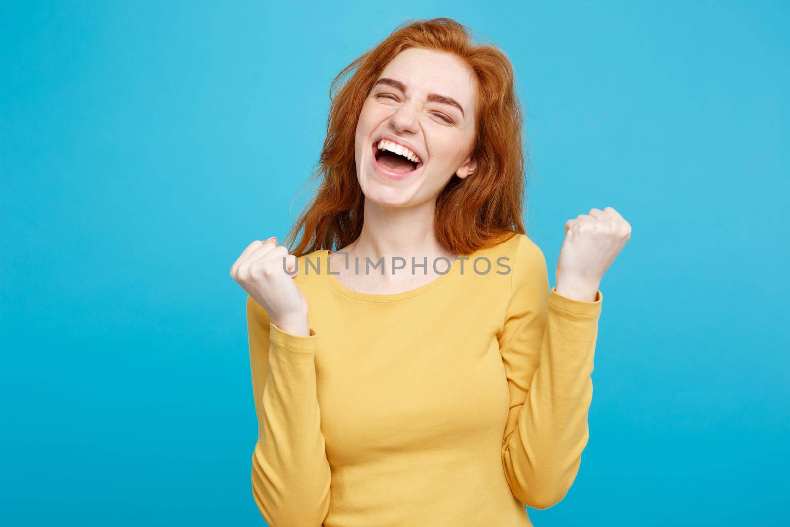 Lifestyle concept - Portrait of cheerful happy ginger red hair girl with joyful and exciting smiling to camera. Isolated on Blue Pastel Background. Copy space.