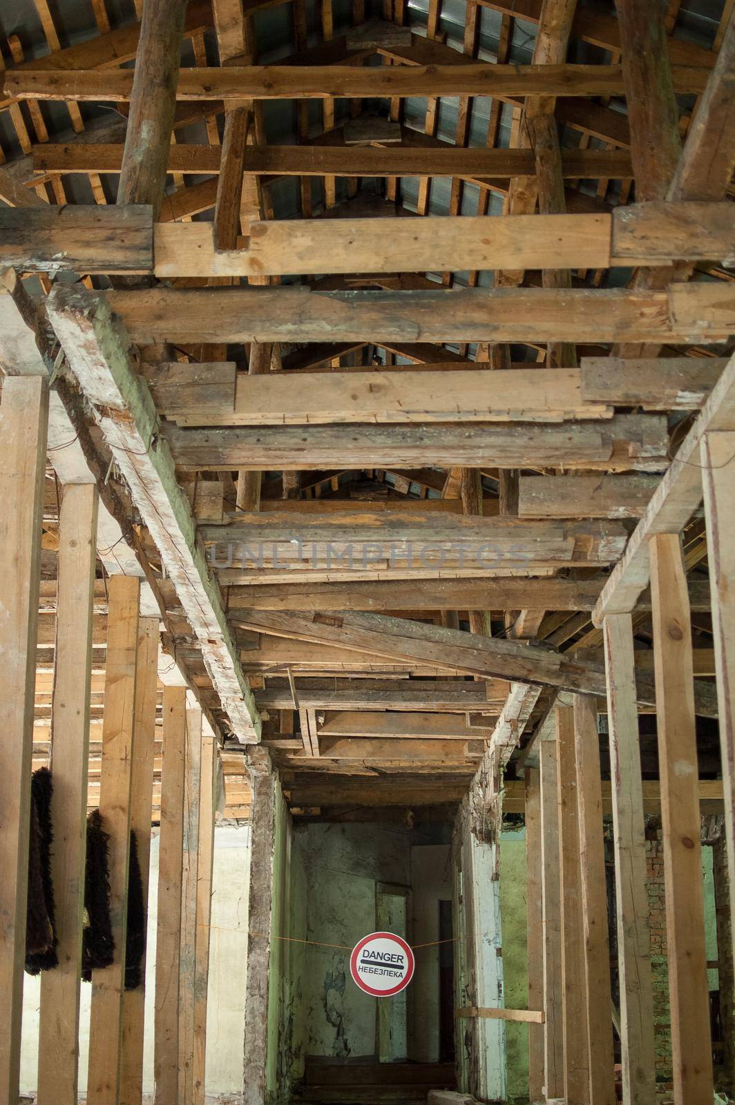 Old wrecked house with 'Danger' in English and in Ukrainian warning sign, abandoned building, uninhabitable place by balinska_lv