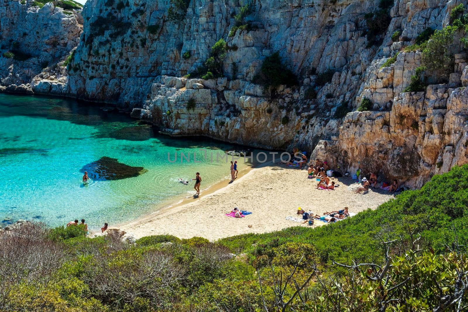 People swimming in the clear blue waters of Proti Island, near Marathopoli, Messinia at Peloponnese. by ankarb