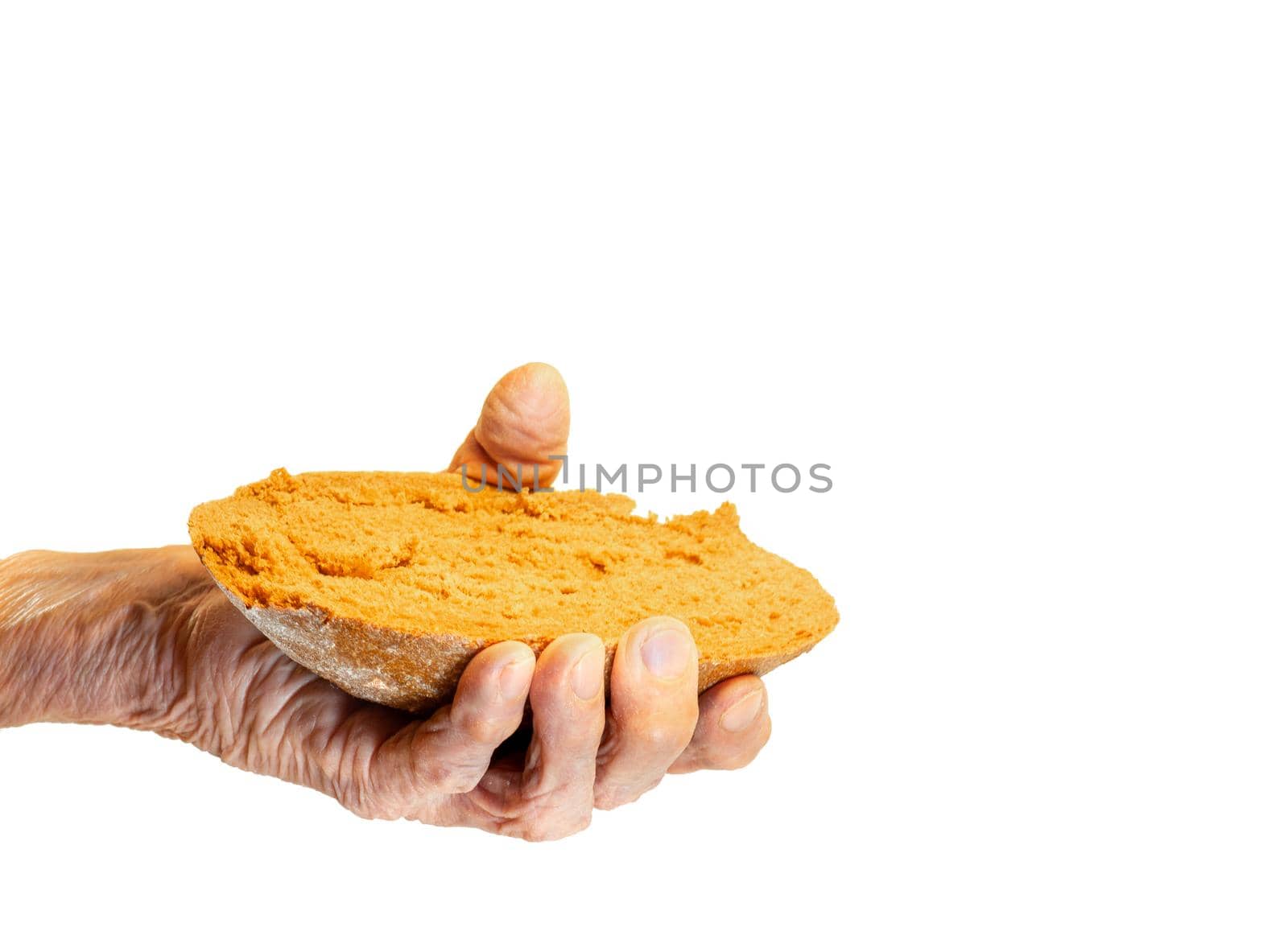 Elderly woman's hand holds out a piece of rye bread on a white background by Puludi