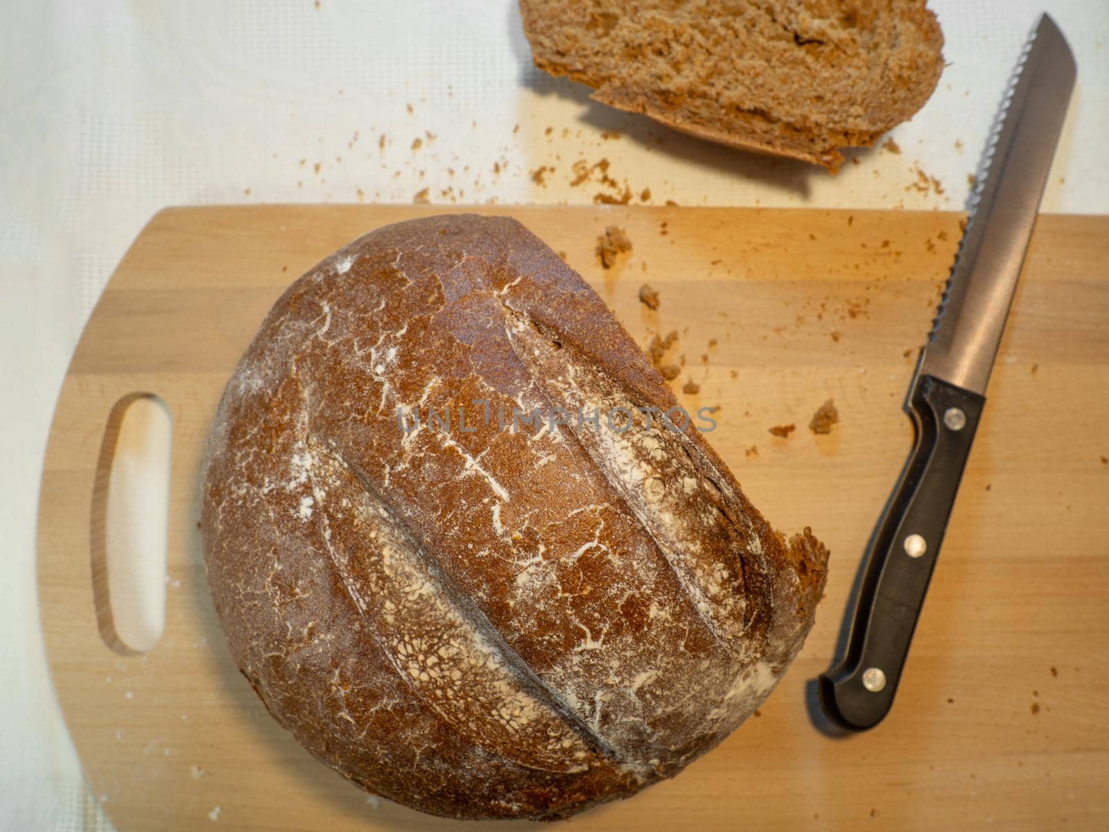 Cut rye bread lies on the board. Fresh bakery by Puludi