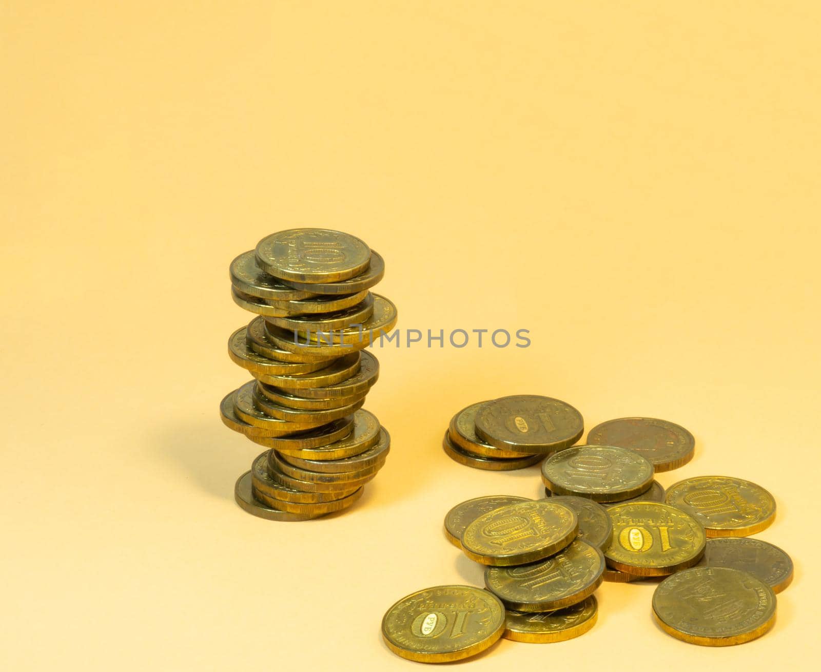 Turret  made of coins. Money on yellow background by Puludi