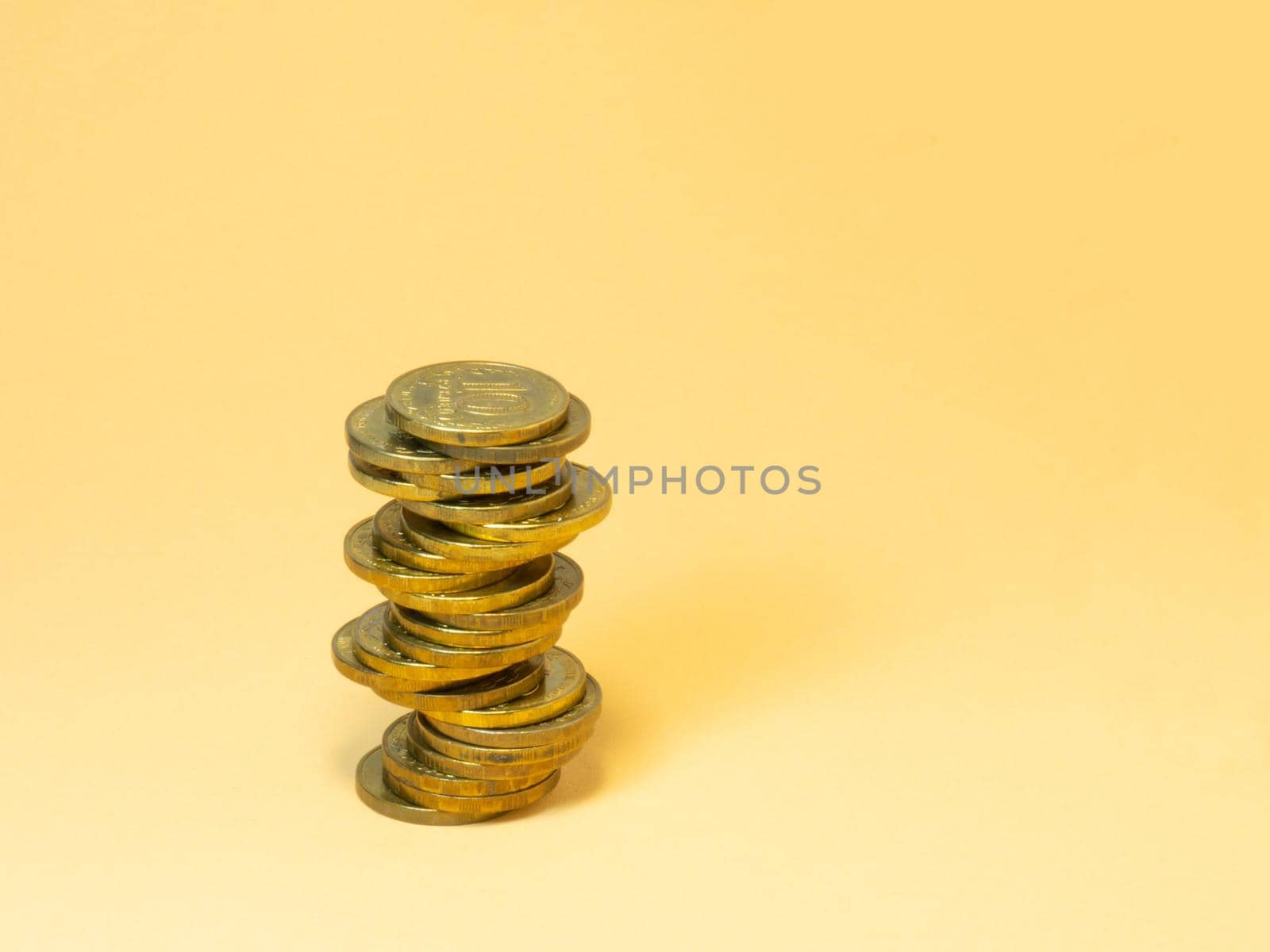A turret made of coins. Money on yellow background by Puludi