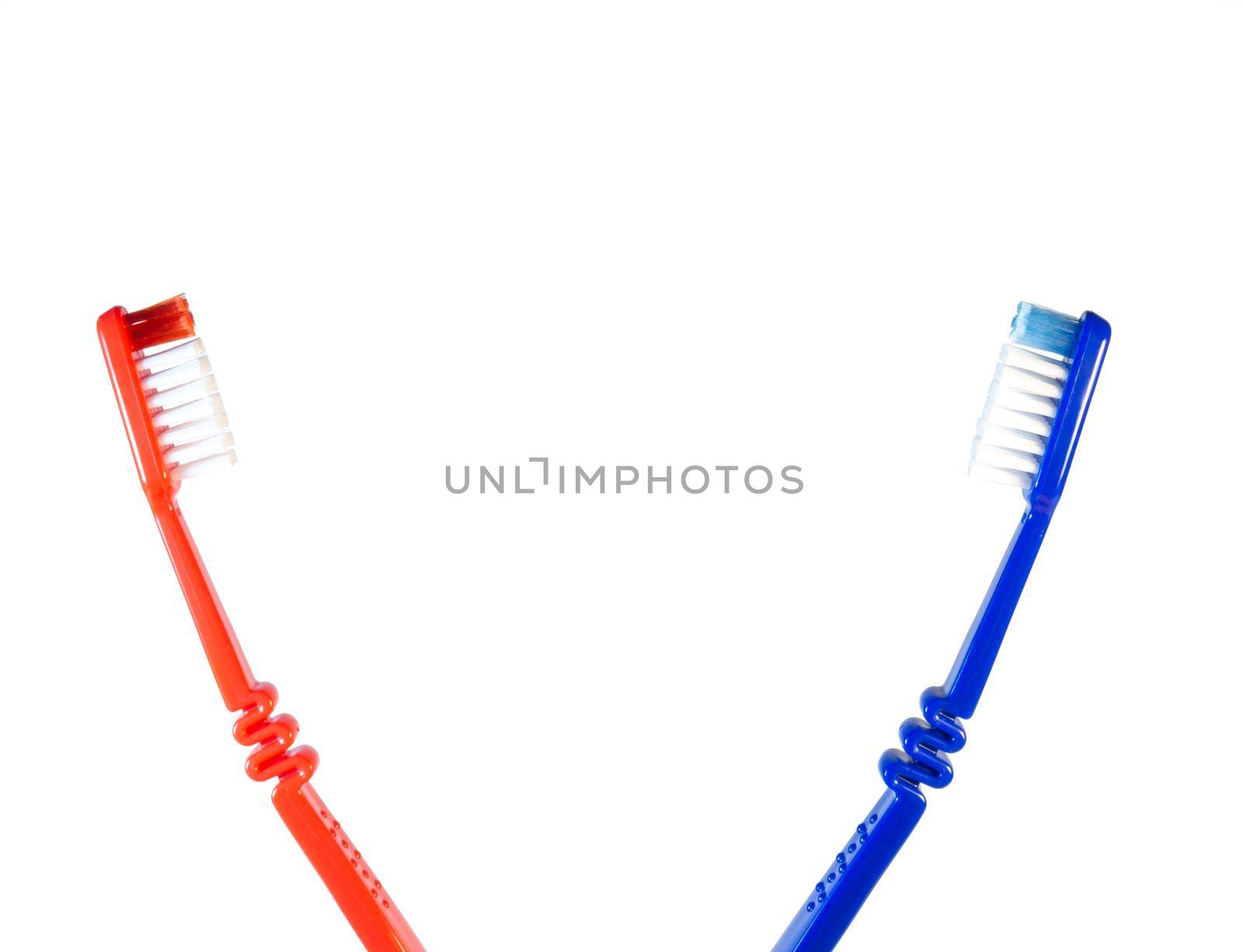 Two toothbrushes on a white background. Blue and red toothbrushes by Puludi