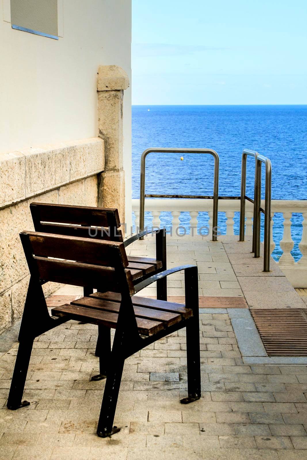 Two brown seats on the street with beautiful view to Benidorm beach, Alicante, Spain.