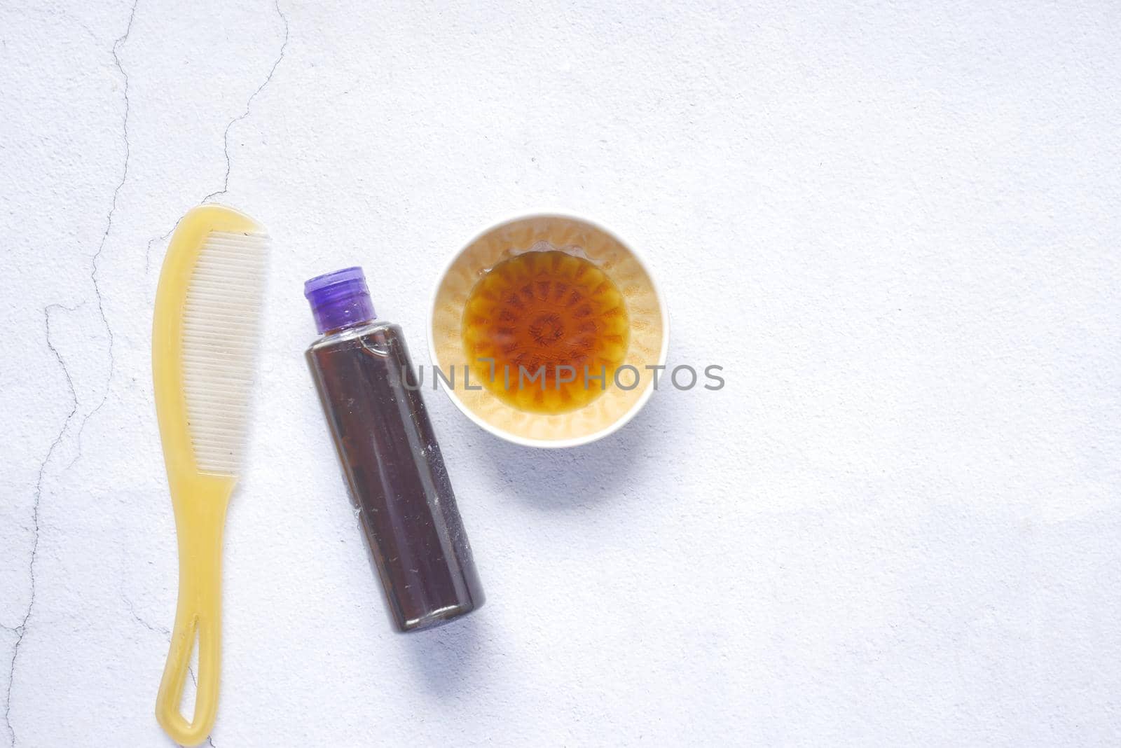 hair oil, comb and container on table , top view