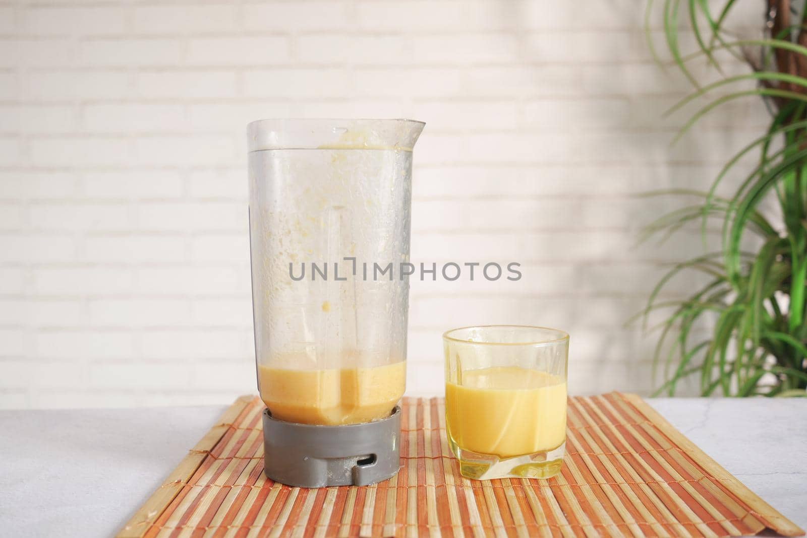 mango smoothie and a blender on table with copy space