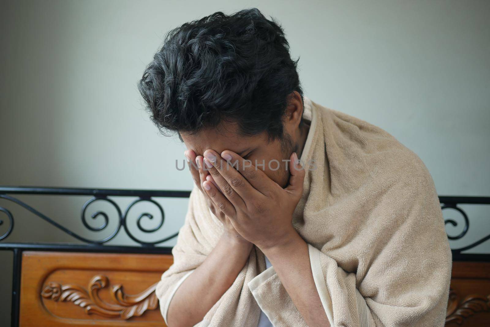 Mature man in blanket coughing while sited on bed by towfiq007