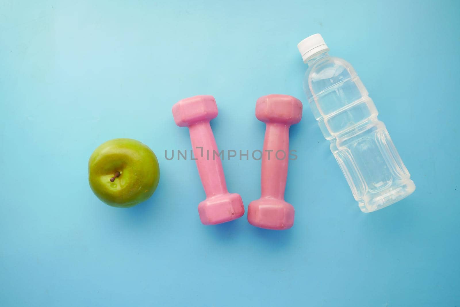 fresh drinking water, apple and a pink color dumbbell on table by towfiq007