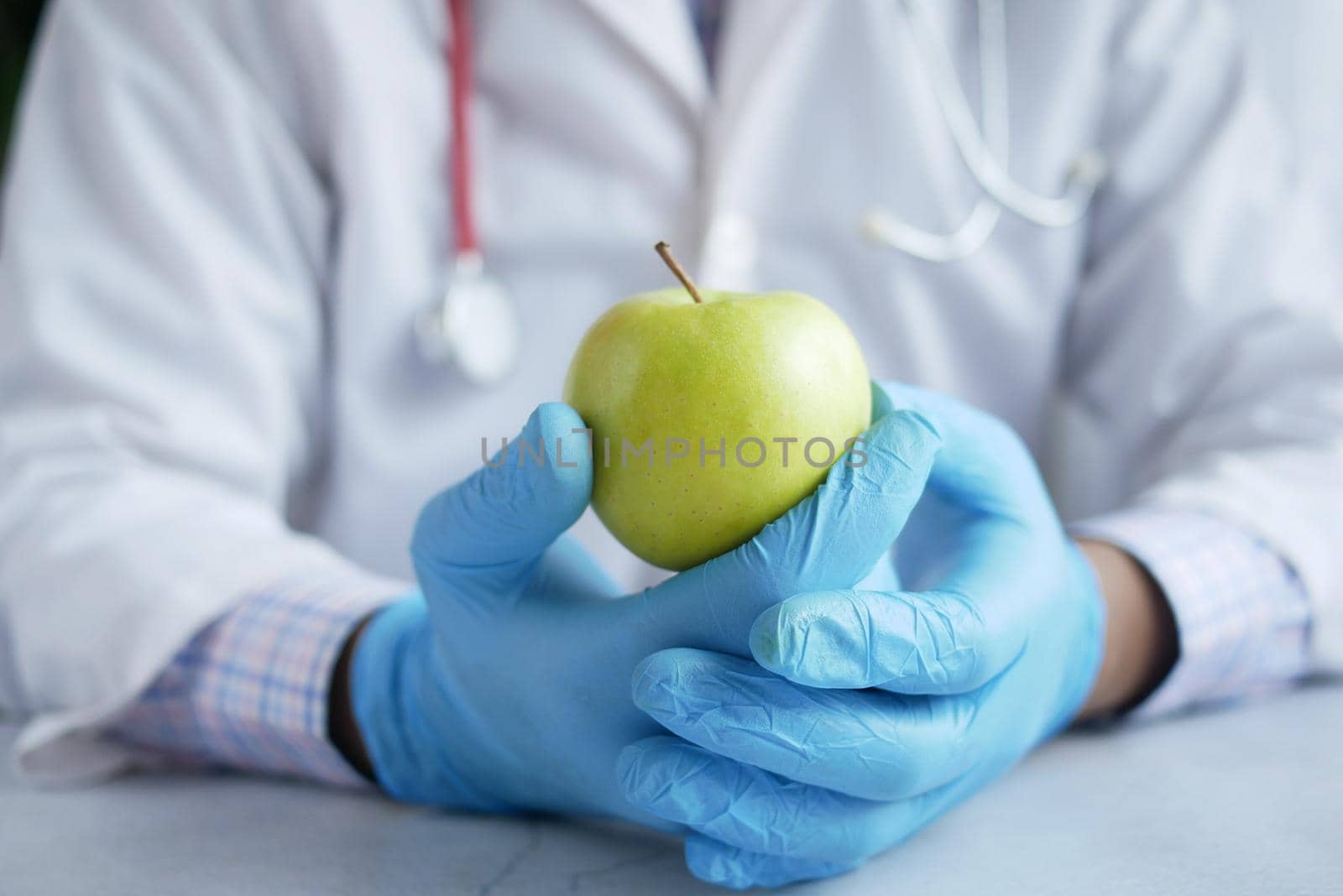 doctor's hand holding green apple while sited ,