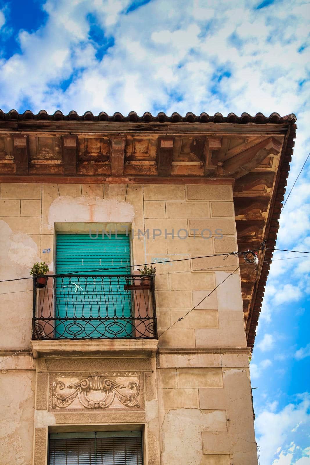 Old house facade with rusty balcony and blind by soniabonet