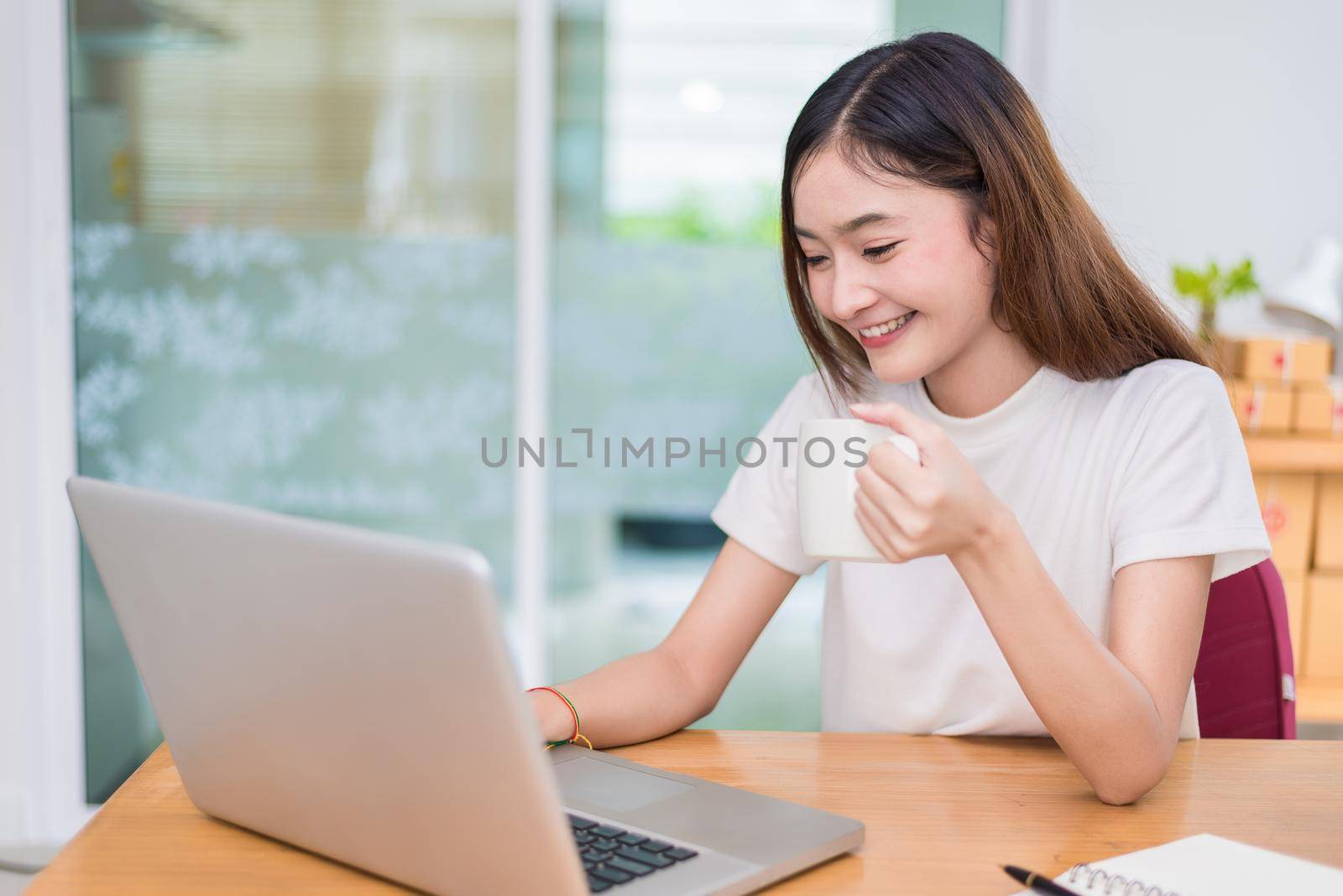 Asian woman enjoy herself while using laptops and internet in office. Business and marketing and part time concept. On line shopping and business success theme. Happy mood doing working job.