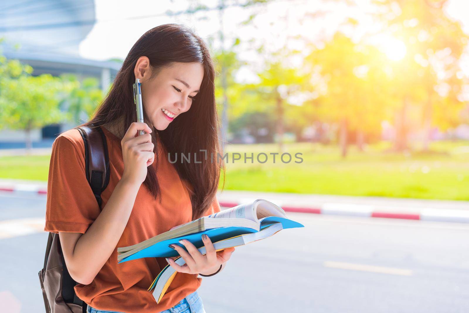 Asian young college woman doing homework and reading books for final examination in campus. University and student concept. Lifestyle and beauty concept. Teenager and Learning theme. by MiniStocker