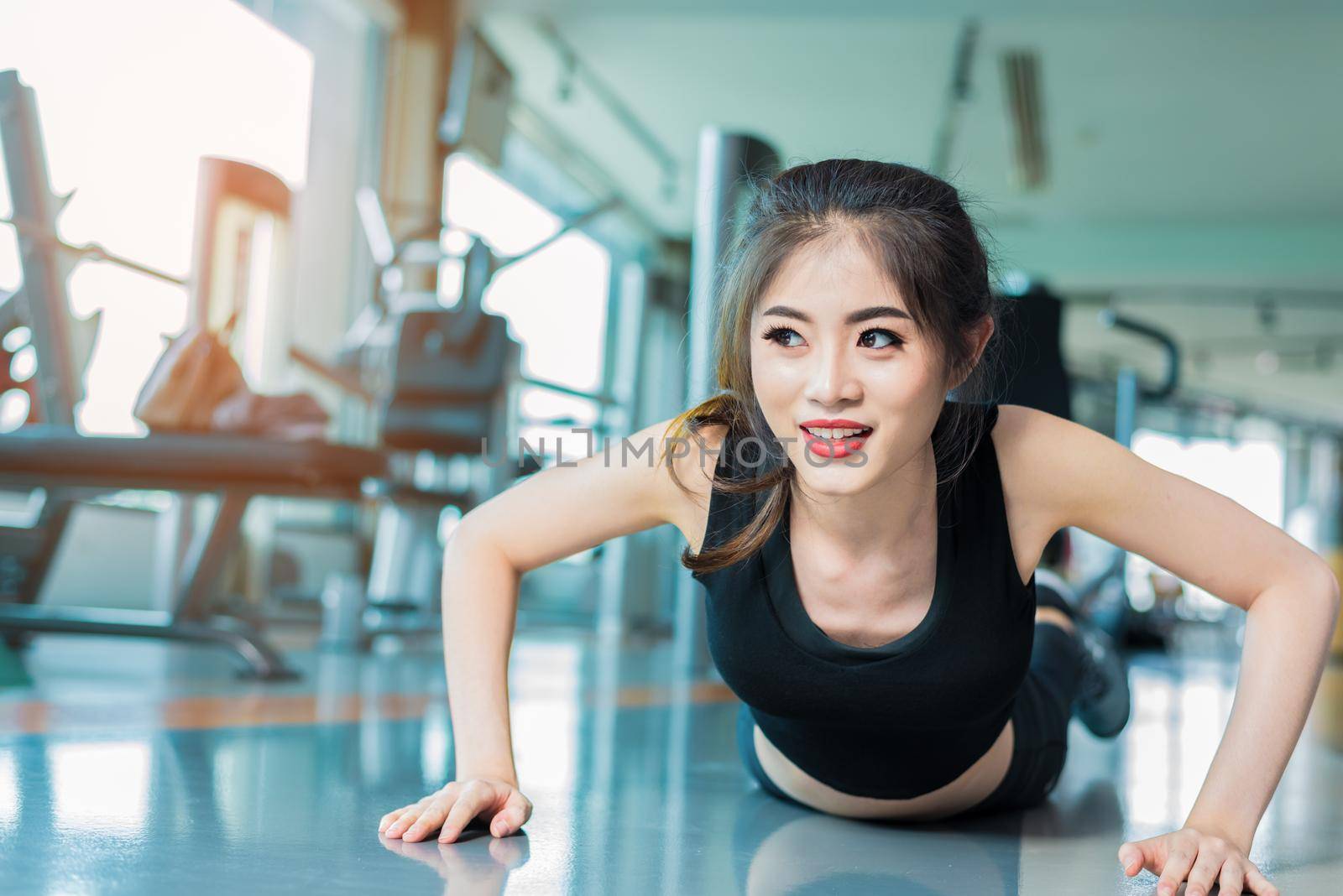 Asian woman fitness girl do pushing ups at fitness gym. Healthcare and Healthy concept. Training and Body build up theme. Strength and Beauty concept