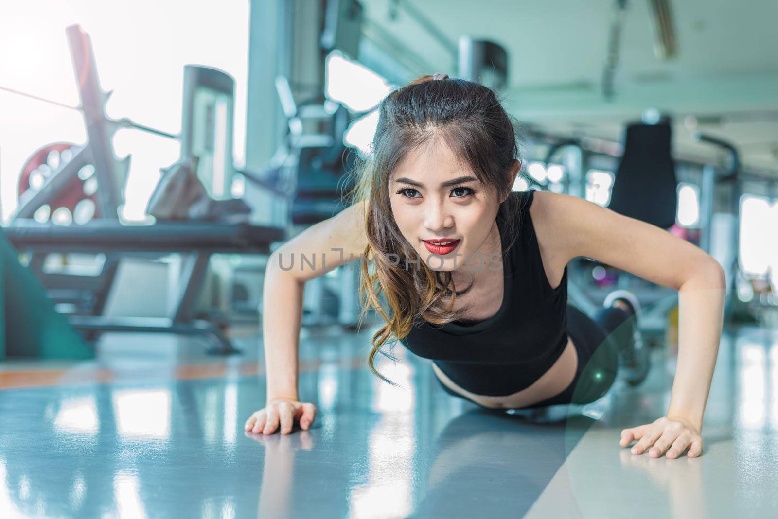 Asian woman fitness girl do pushing ups at fitness gym. Healthcare and Healthy concept. Training and Body build up theme. Strength and Beauty concept