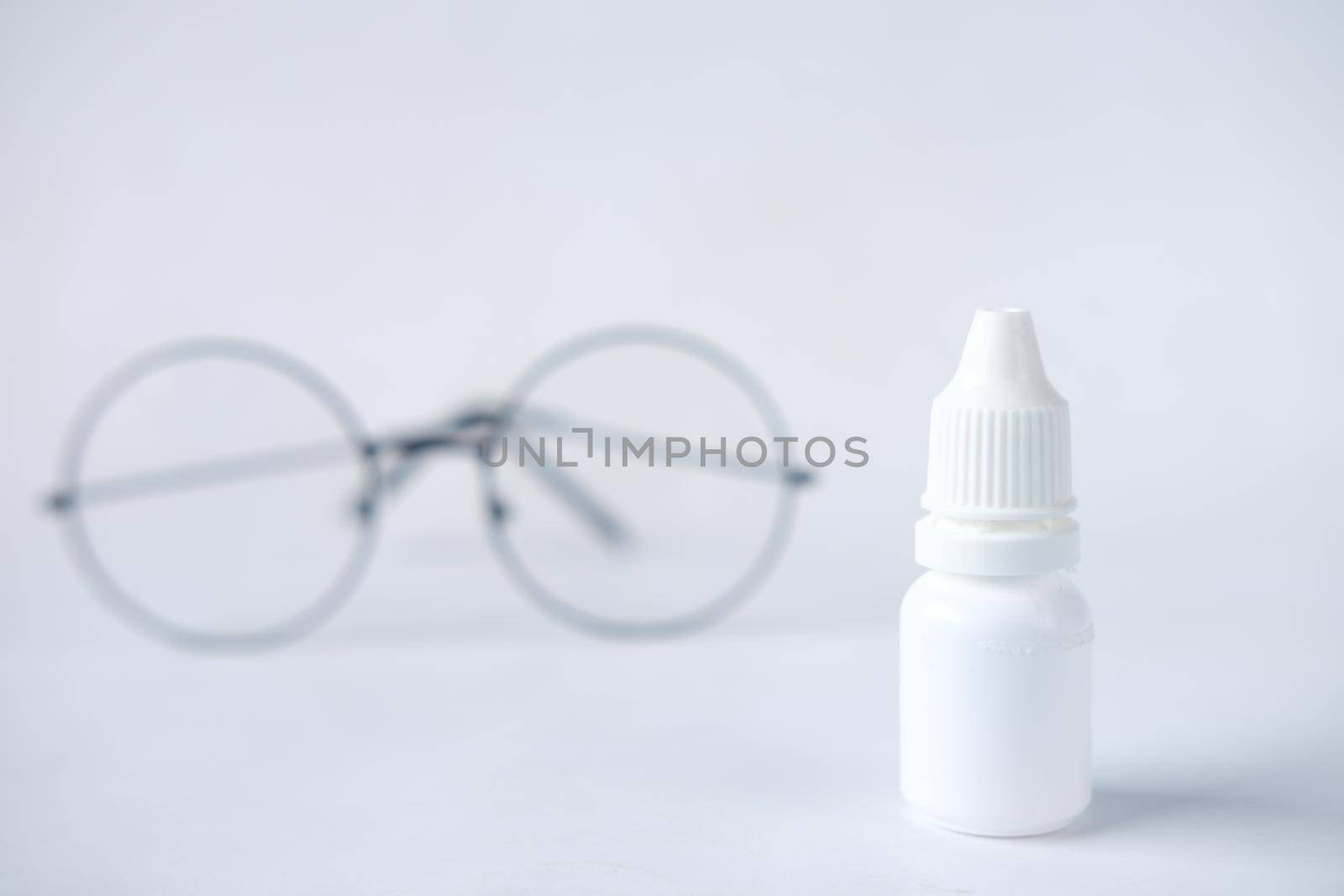 close up of eye drop bottle and eyeglass on white, by towfiq007