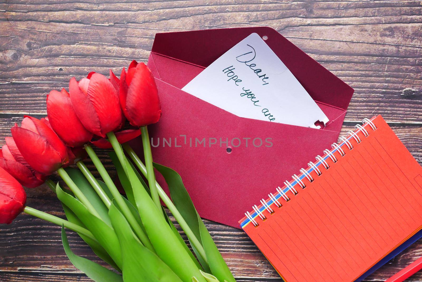 envelope, paper and tulip flower on table ,