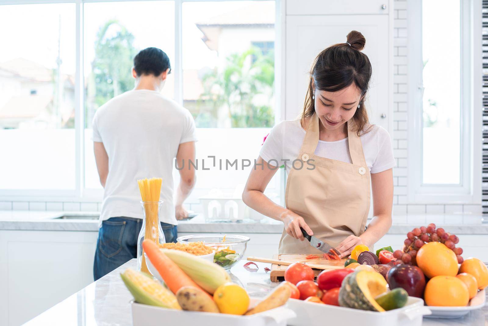 Asian lovers or couple cooking and slicing vegetable in kitchen room. Holiday and Honeymoon concept. Valentine day and wedding theme