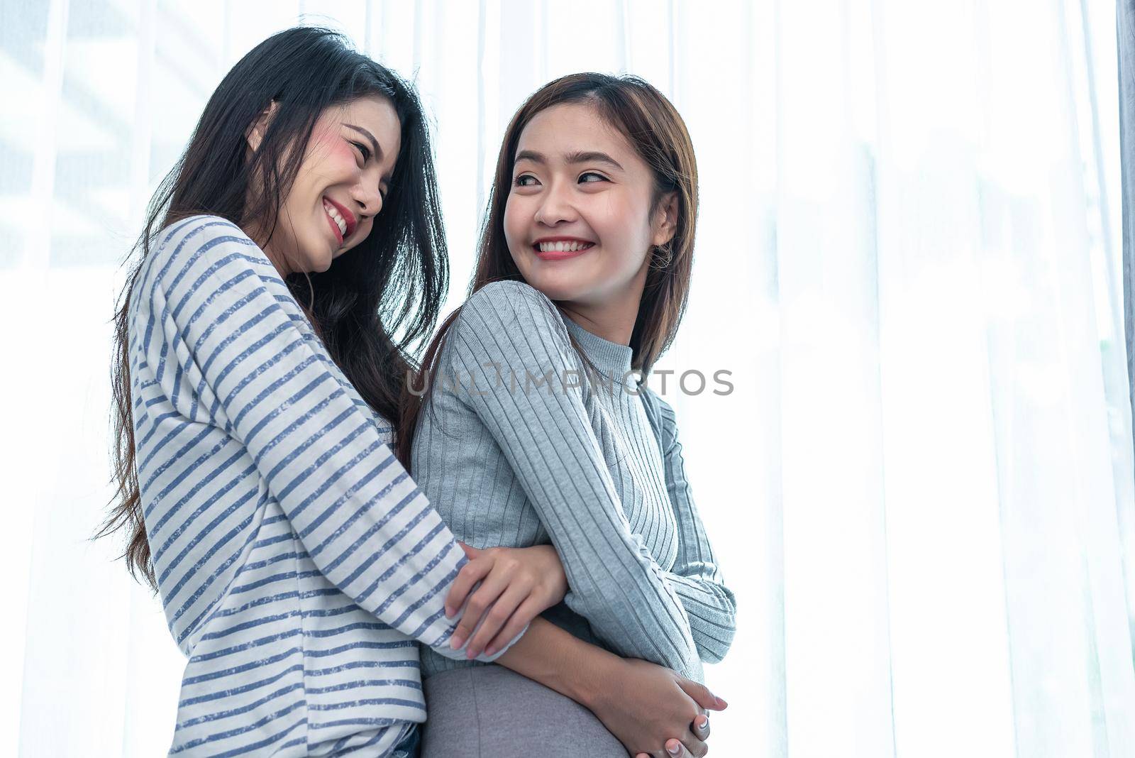 Two Asian Lesbian women hug and embracing together in bedroom. Couple people and Beauty concept. Happy lifestyles and home sweet home theme. Homosexual life theme. Love scene making of female