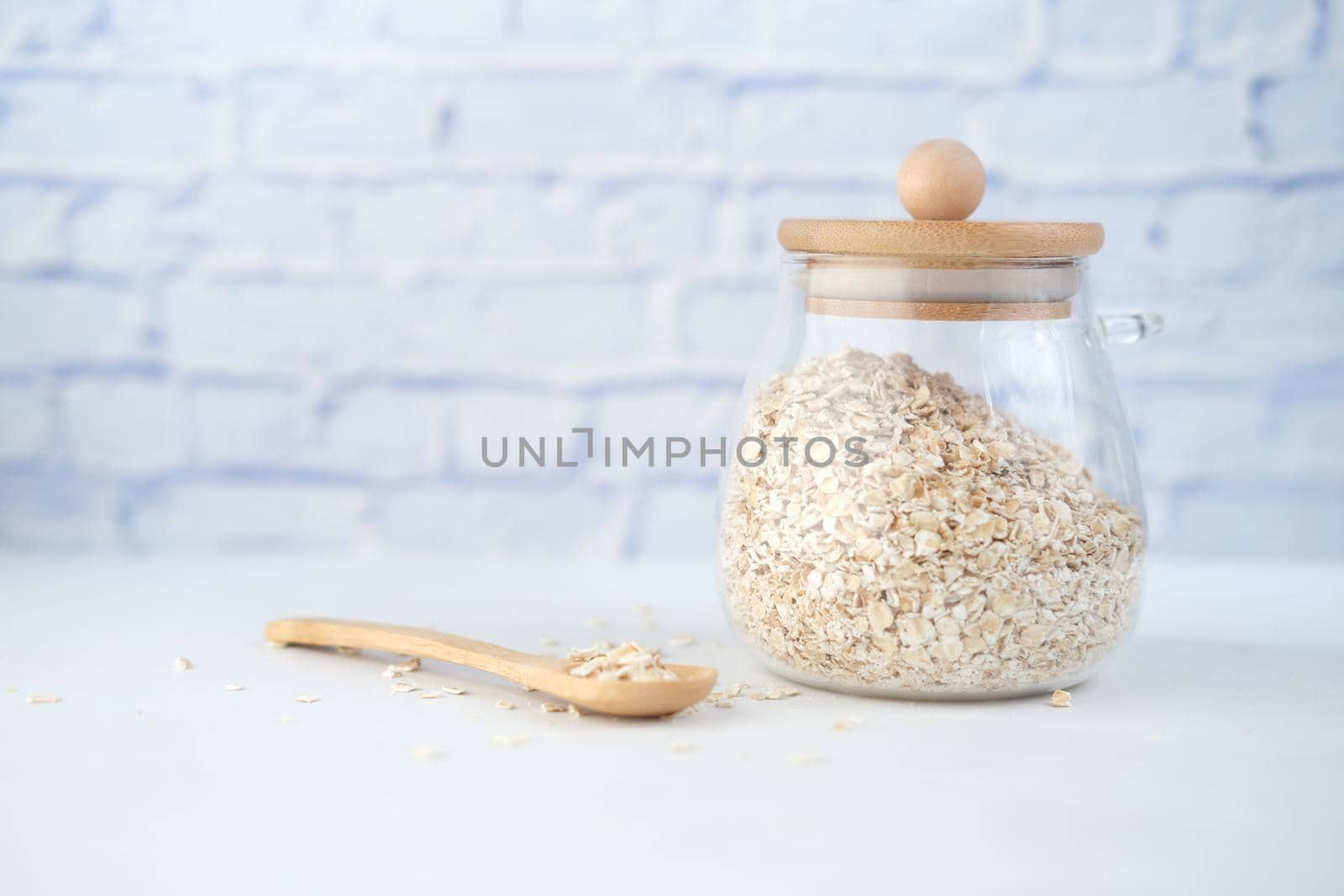oats flakes in a jar with spoon on table .