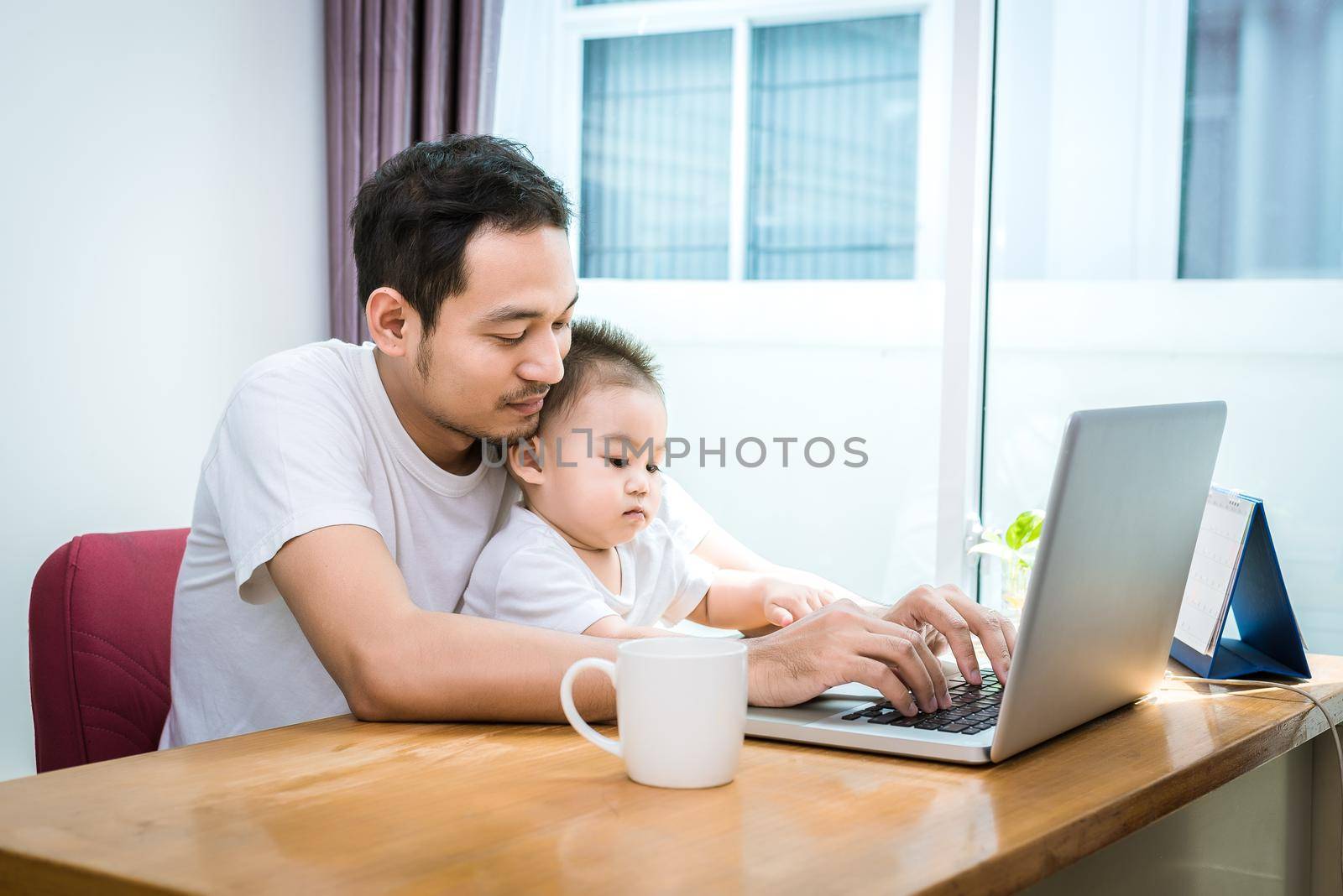 Single dad and son using laptop together happily. Technology and Lifestyles concept. Happy family and baby theme.