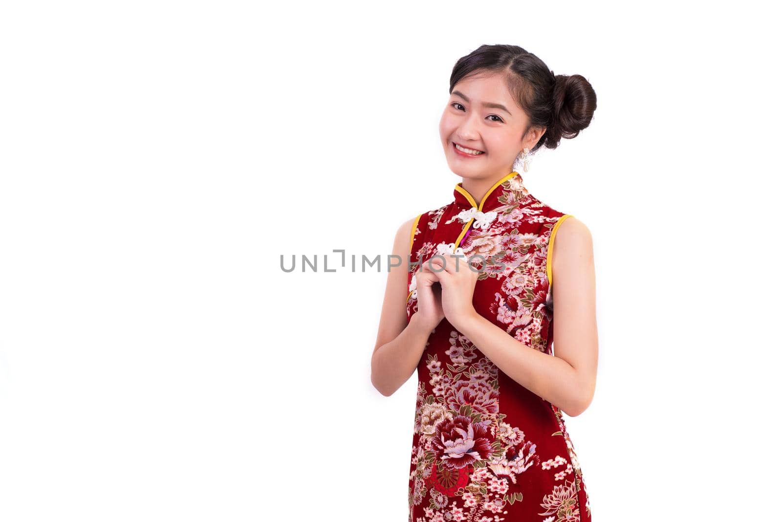 Young Asian beauty woman wearing cheongsam and blessing or greeting gesture in Chinese new year festival event on isolated white background. Holiday and Lifestyle concept. Qipao dress wearing