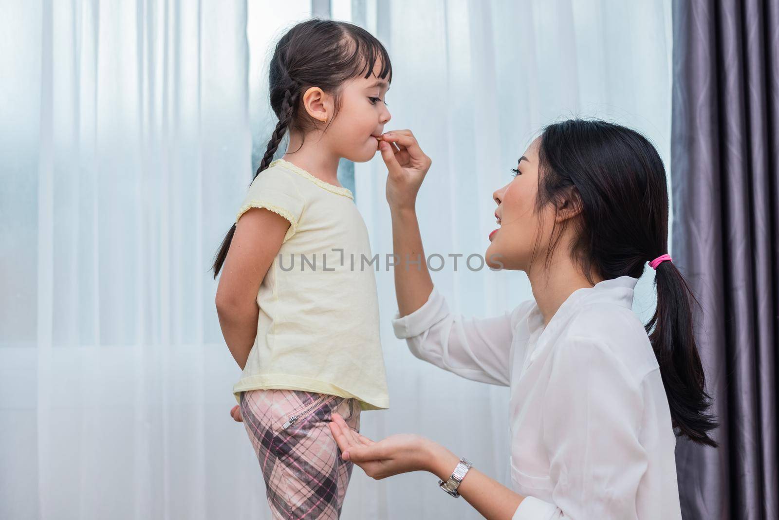 Mom feeding kids with potato chip. Teacher feeding student with snack. Back to school and Education concept. Children and kids theme. Home sweet home and Nursery theme.