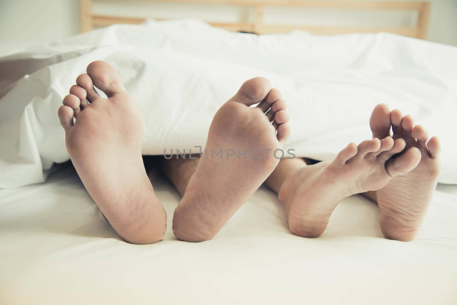Barefoot of lovers under blanket in bedroom. Vacation and Happiness of sexual. Valentines day theme. Holiday morning theme