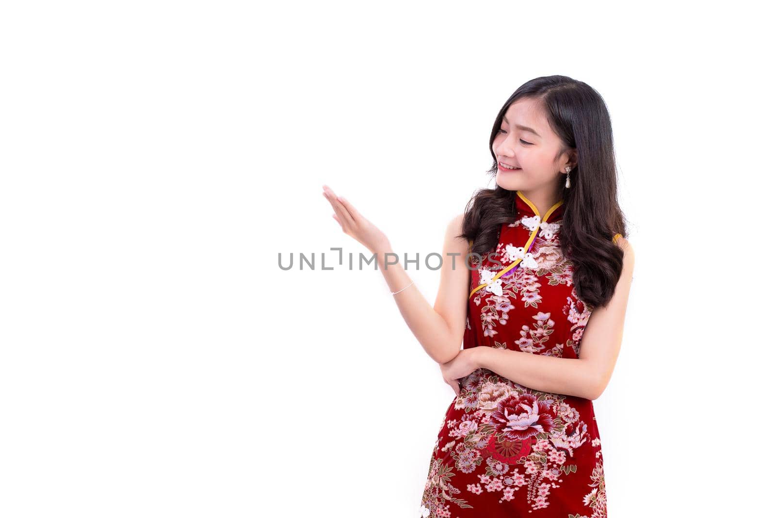Young Asian beauty woman wearing cheongsam and presenting with hands gesture in Chinese new year festival event on isolated white background. Holiday and Lifestyle concept. Qipao dress wearing