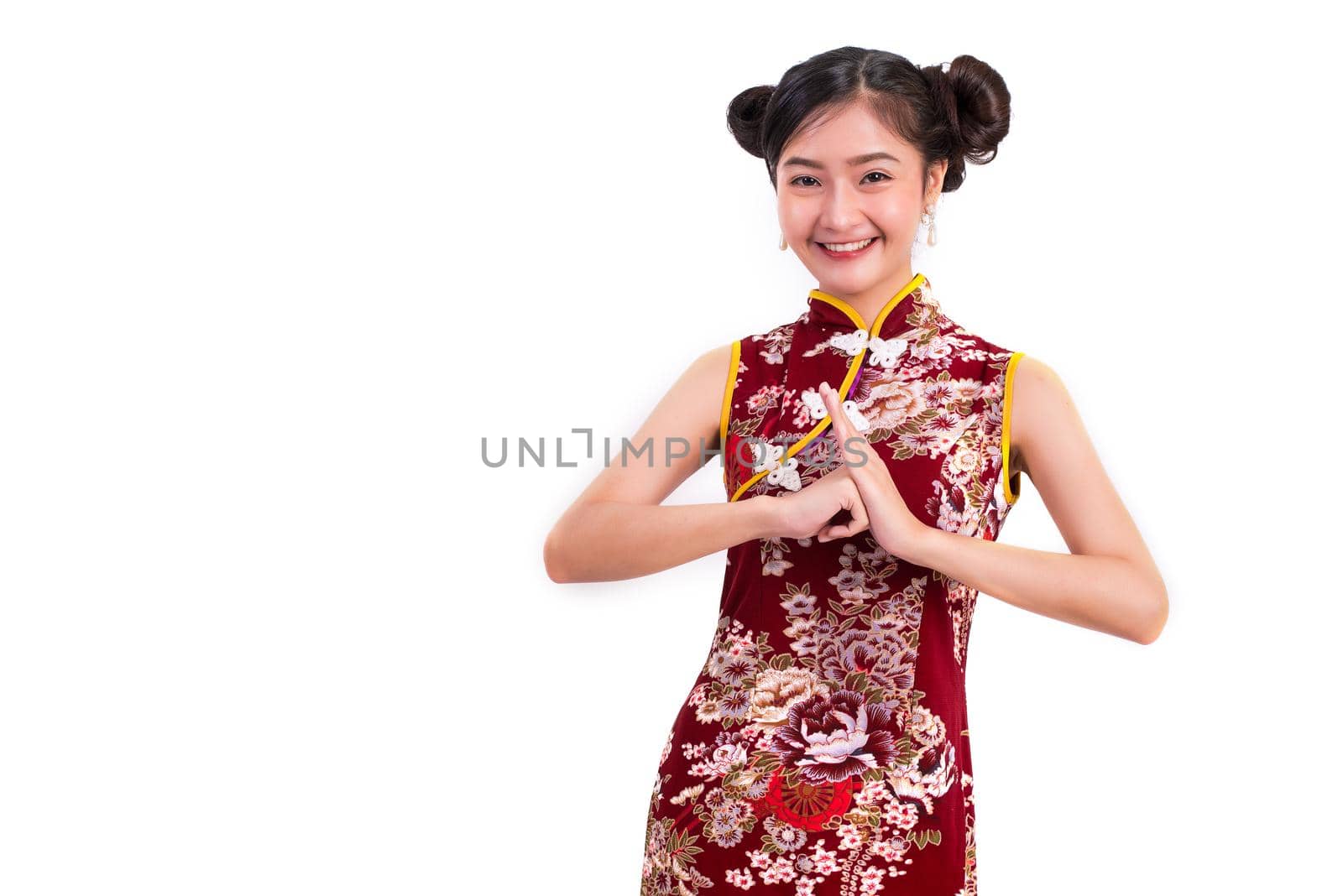 Young Asian beauty woman wearing cheongsam and blessing or greeting gesture in Chinese new year festival event on isolated white background. Holiday and Lifestyle concept. Qipao dress wearing