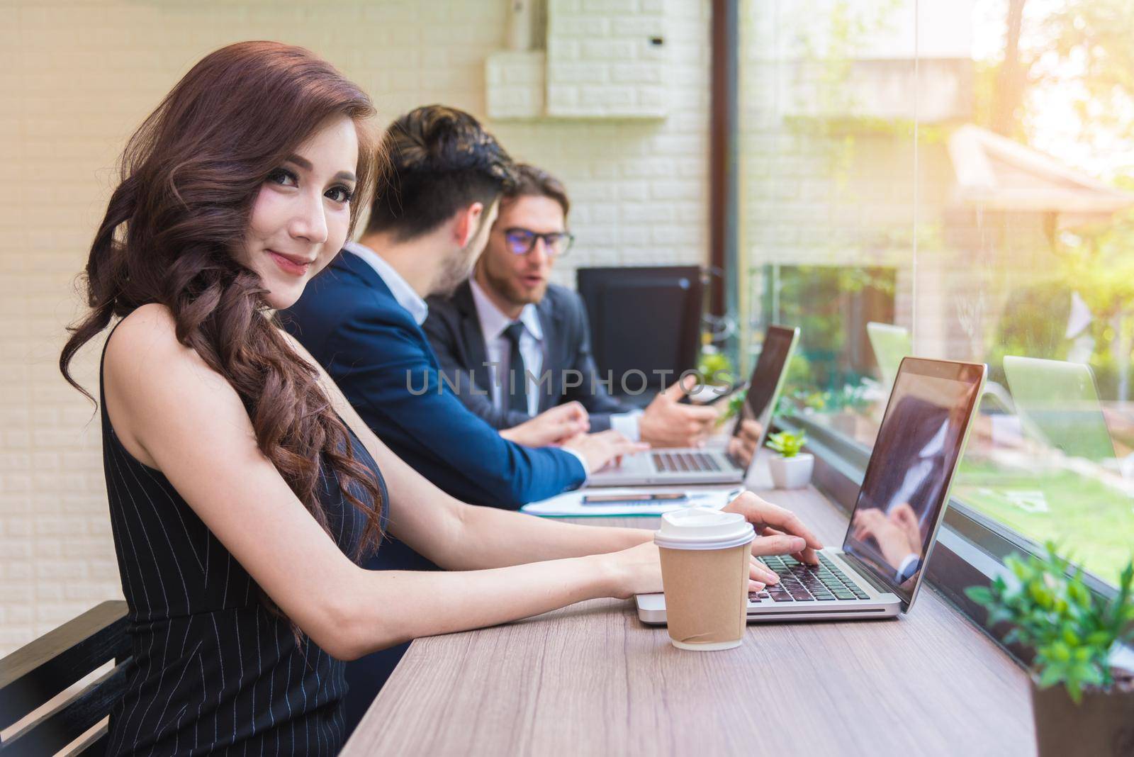 Business woman working with business team by laptop computer. Beauty and Technology concept. Smart lady and working woman theme. Office and happy life theme. by MiniStocker