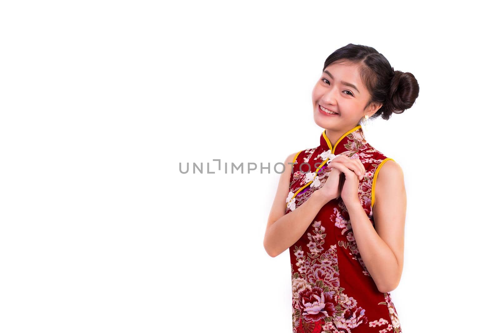 Young Asian beauty woman wearing cheongsam and blessing or greeting gesture in Chinese new year festival event on isolated white background. Holiday and Lifestyle concept. Qipao dress wearing