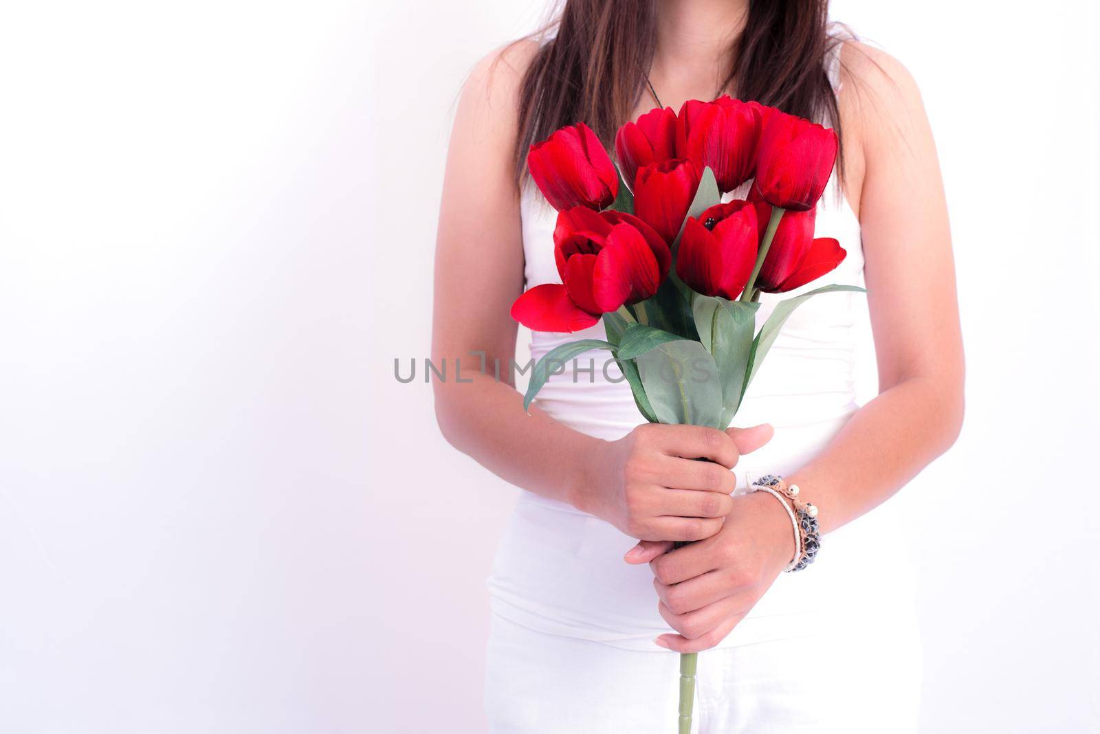 Woman holding red rose flower. Valentines day and  Couples concept. Love and Flirting theme. Close up at rose. Body part and headless theme