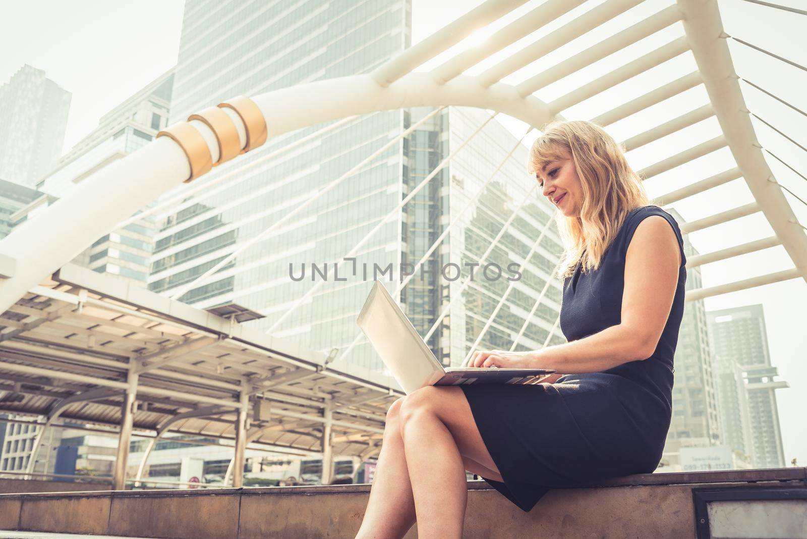 Businesswoman working with laptop.  Successful and Happiness concept. Technology and Lifestyle concept City and urban theme. Happy life at Outdoors theme