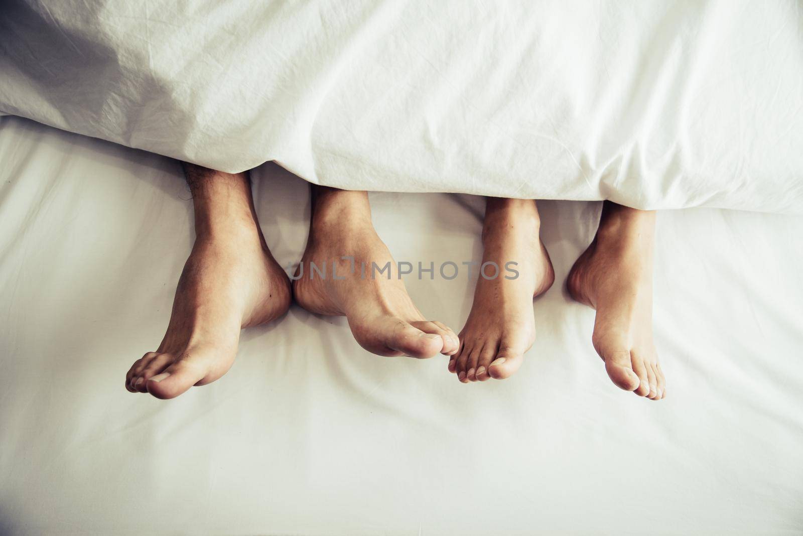 Barefoot of lovers under blanket in bedroom. Vacation and Happiness of sexual. Valentines day theme. Holiday morning theme