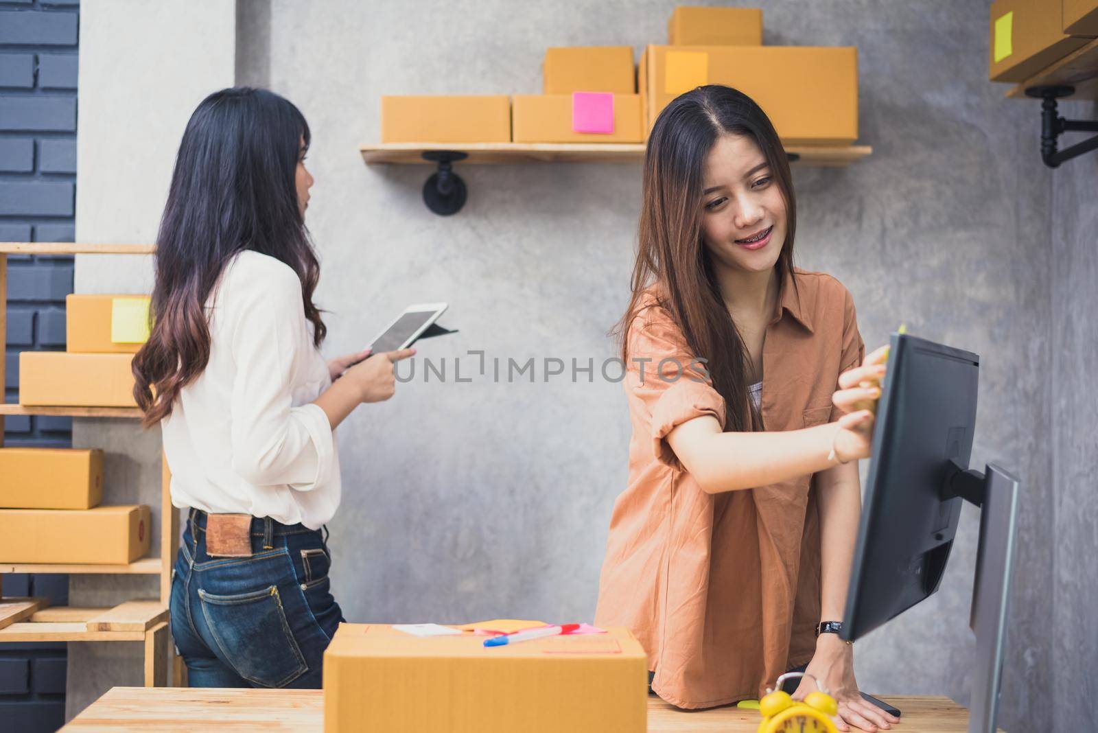 Two young Asian people startup small business entrepreneur SME distribution warehouse with parcel mail box. small  owner home office. Online marketing and product packaging and delivery service