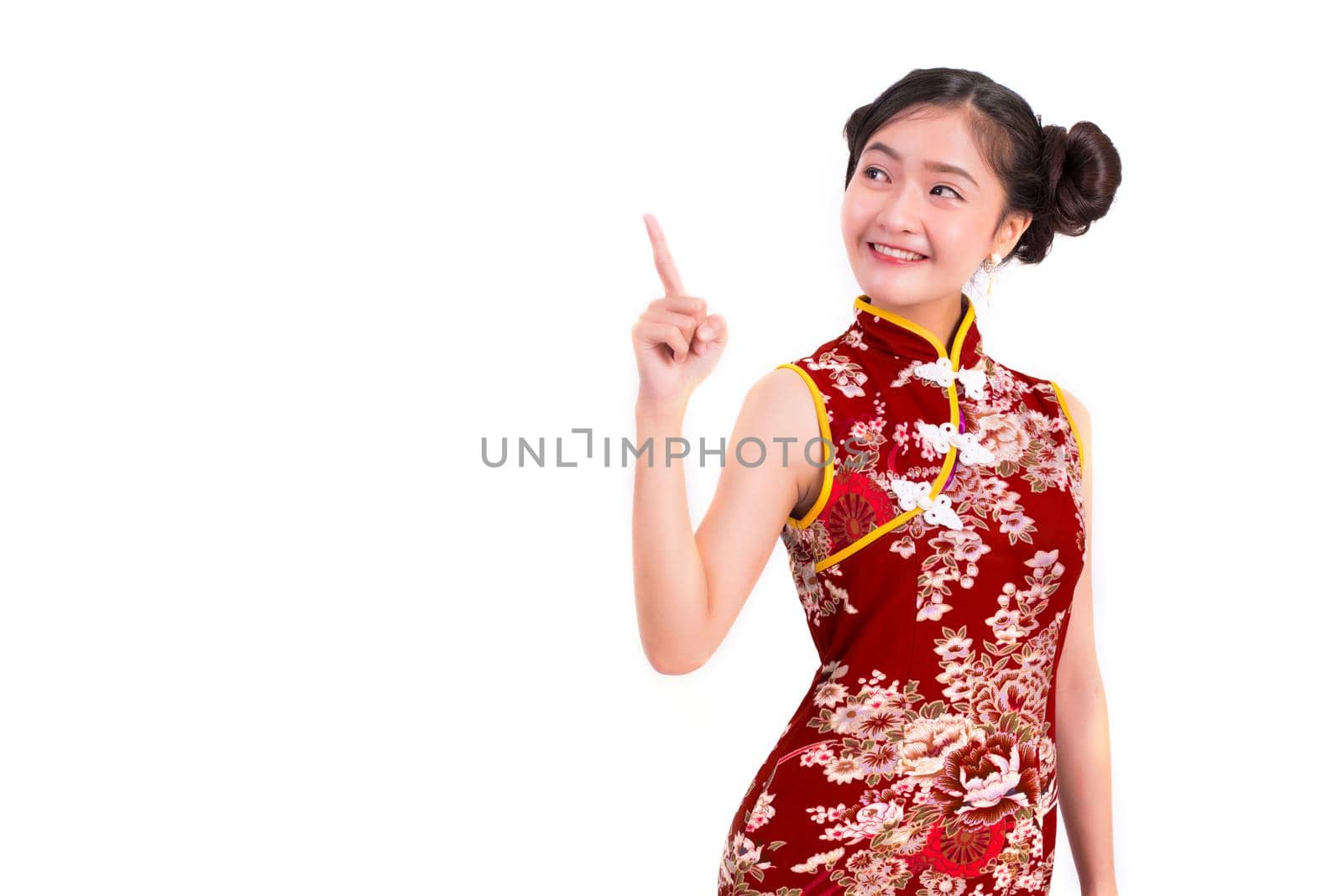 Young Asian beauty woman wearing cheongsam and pointing beside gesture in Chinese new year festival event on isolated white background. Holiday and Lifestyle concept. Qipao dress wearing