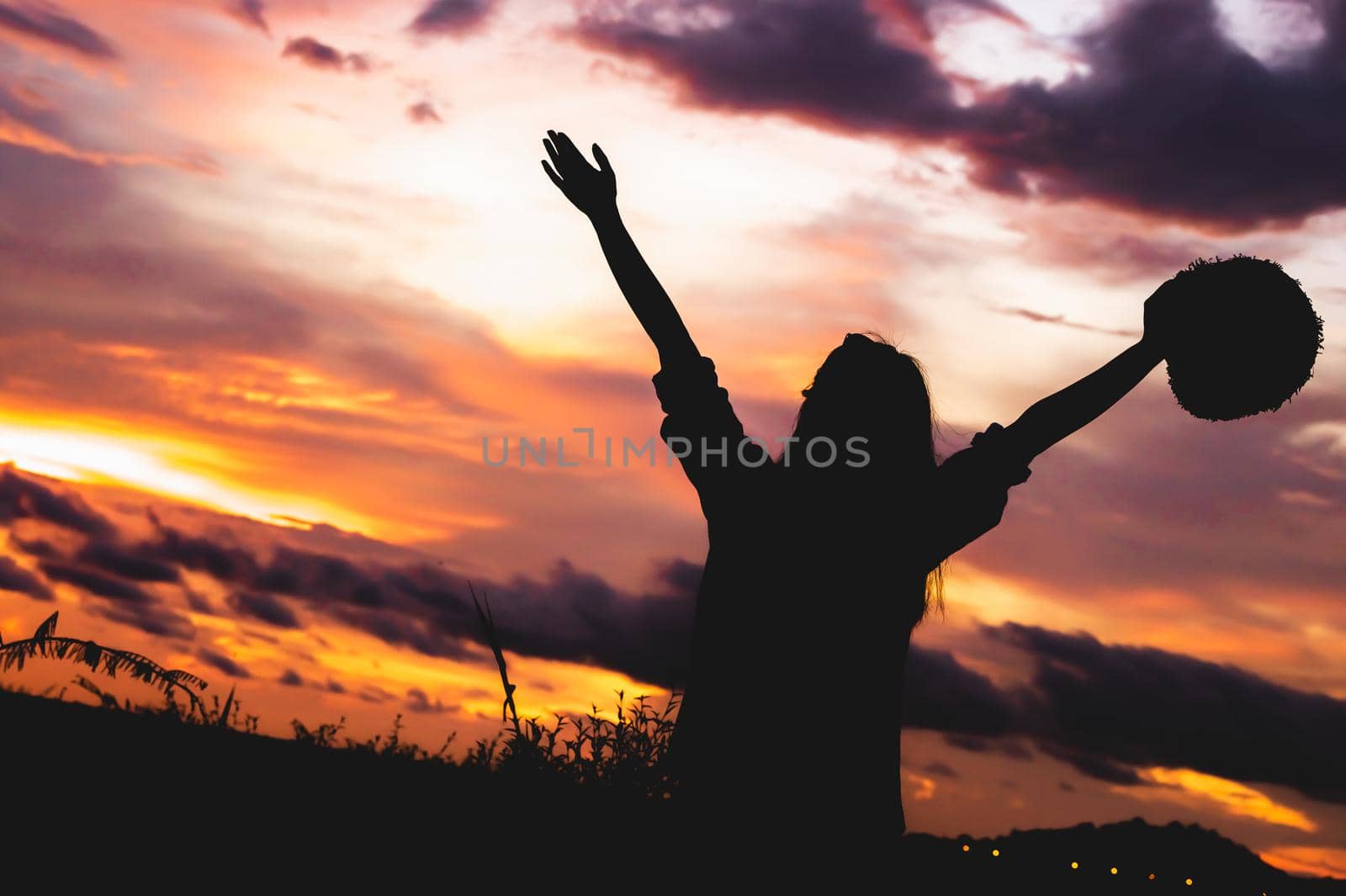 Silhouette of happy woman open arms under sunrise at seaside with sunset  background during travel in holiday. Strong confidence cheerful girl with dawn sky. Sun and nature. Weekend vacation concept