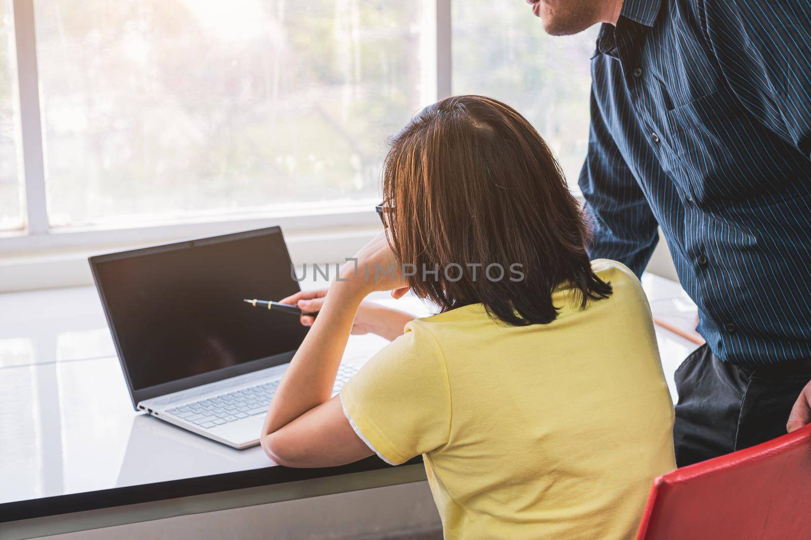 Supervisors are coaching employees in front of the computer and pointing to display screen monitor in office background. Occupation learning and job workshop training. People lifestyles concept.