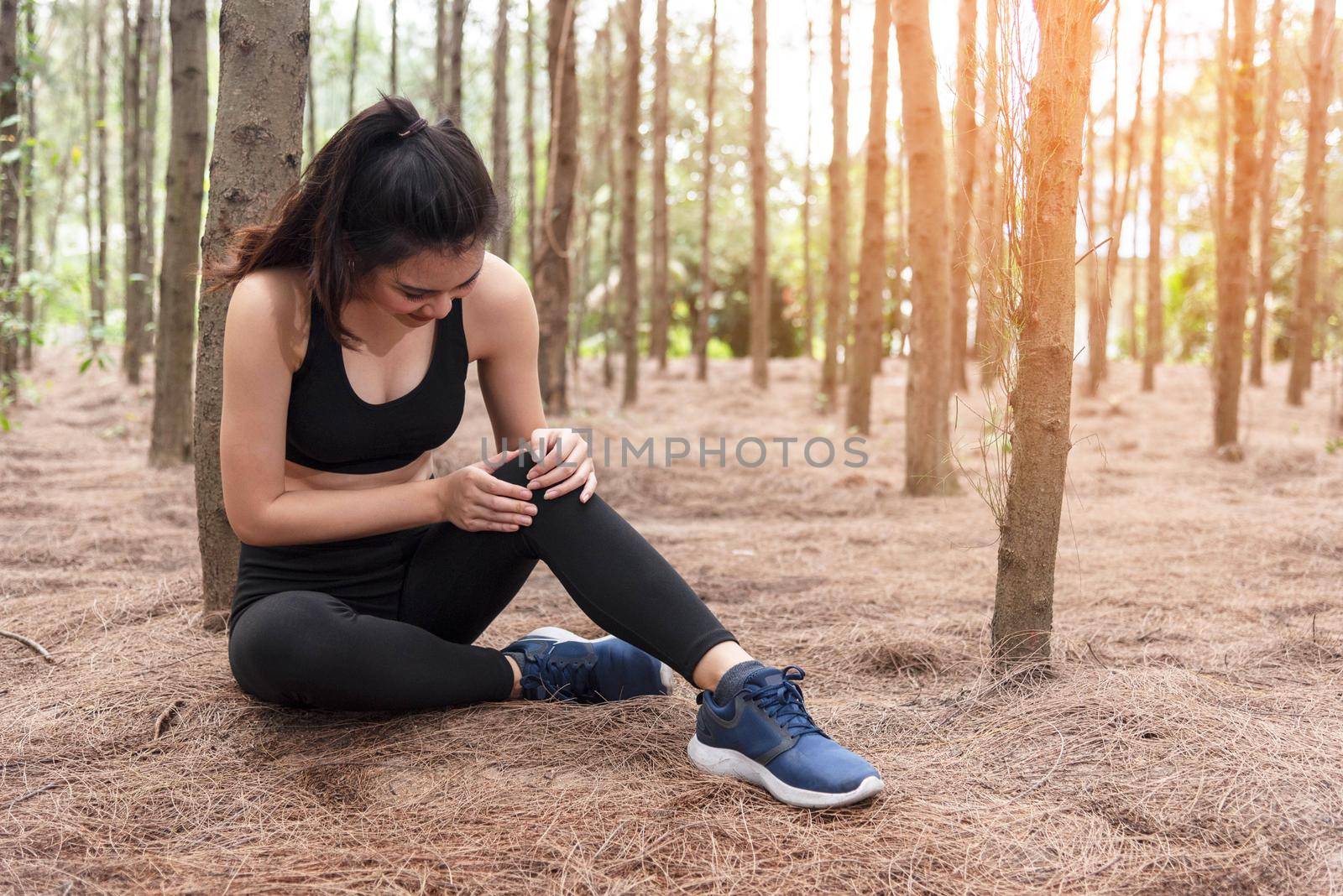 Girl has sport accident injury in forest at outdoors. Healthy and Medicine concept. Adventure and Travel concept. Pine woods theme.