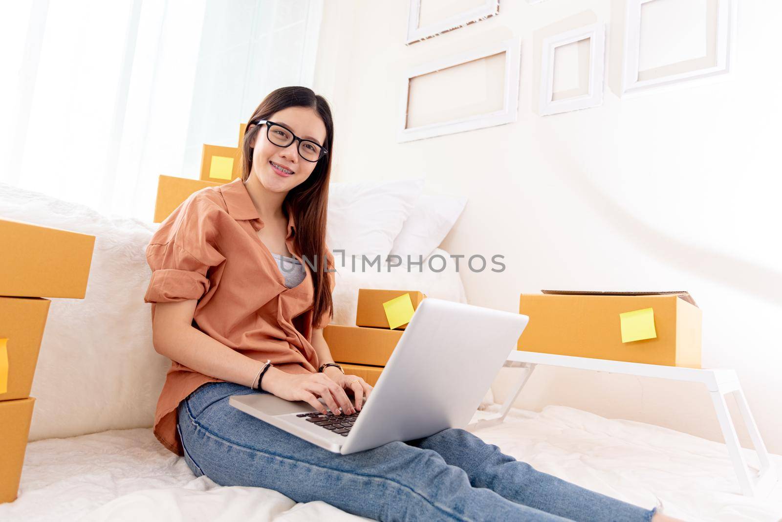 Beauty Asian woman using laptop for customer support in bedroom. Business Technology concept. Delivery online shopping. Service. People lifestyle remote work in domestic house. Looking at camera