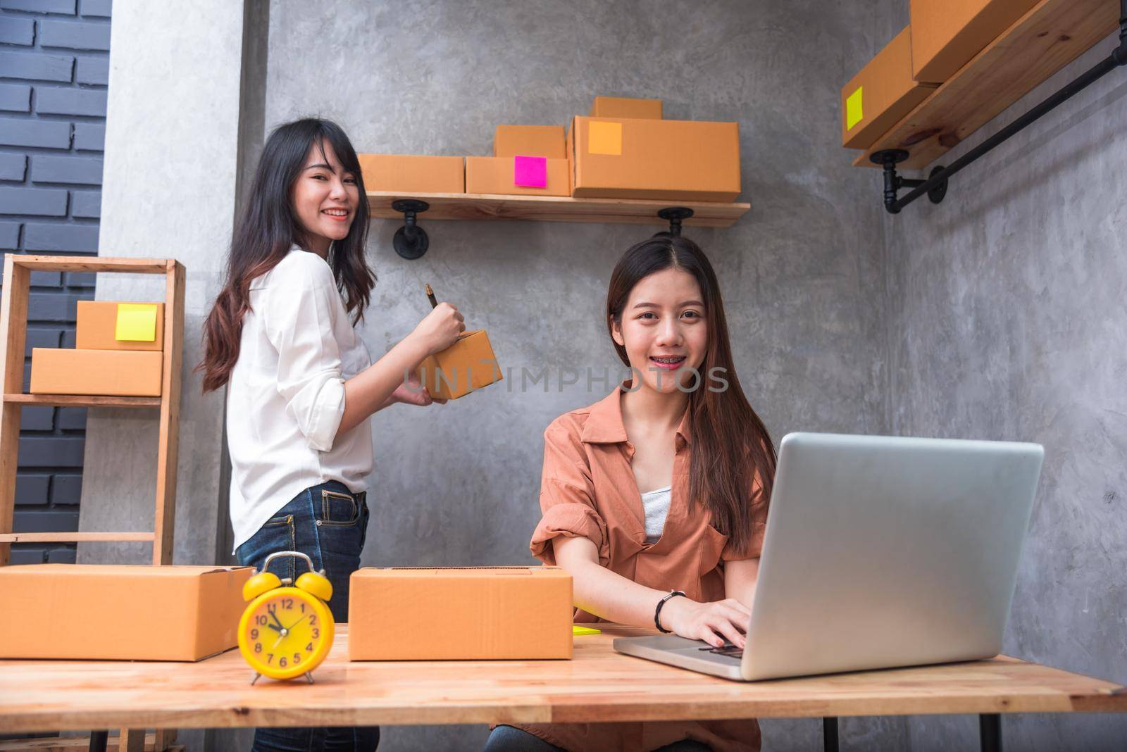 Two young Asian people startup small business entrepreneur SME distribution warehouse with parcel mail box. small  owner home office. Online marketing and product packaging and delivery service