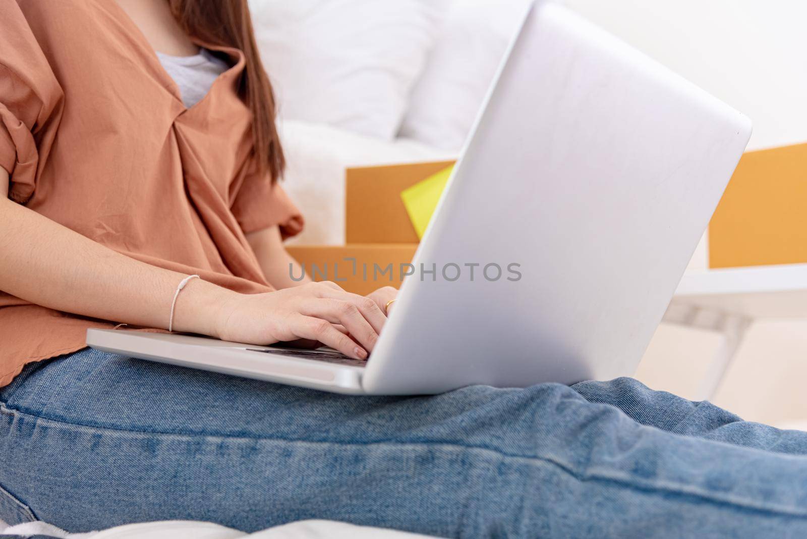 Closeup of laptop using by woman for online shopping delivery business at home. Girl typing on keyboard by hand. People lifestyle and occupation concept. Entrepreneur work from home and shop owner